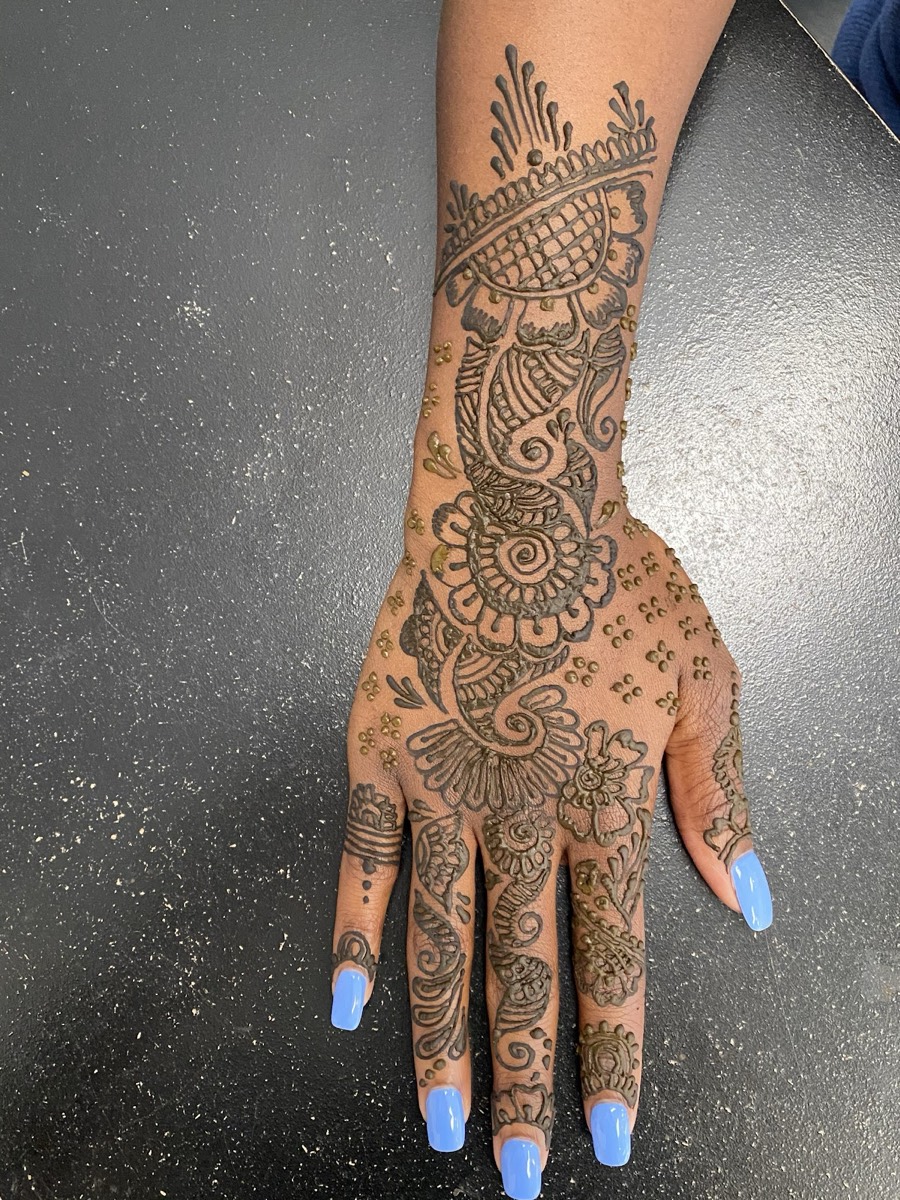 Intricate henna design across the hand and fingers